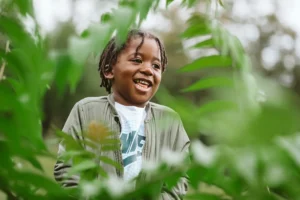 Kind durch Blätter fotografiert