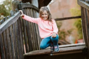 Mädchen auf einem Holzklettergerüst